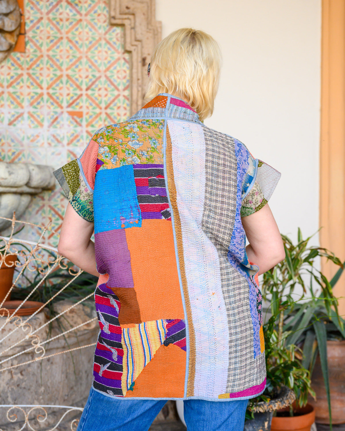 person wearing a colorful quilted short sleeve jacket.